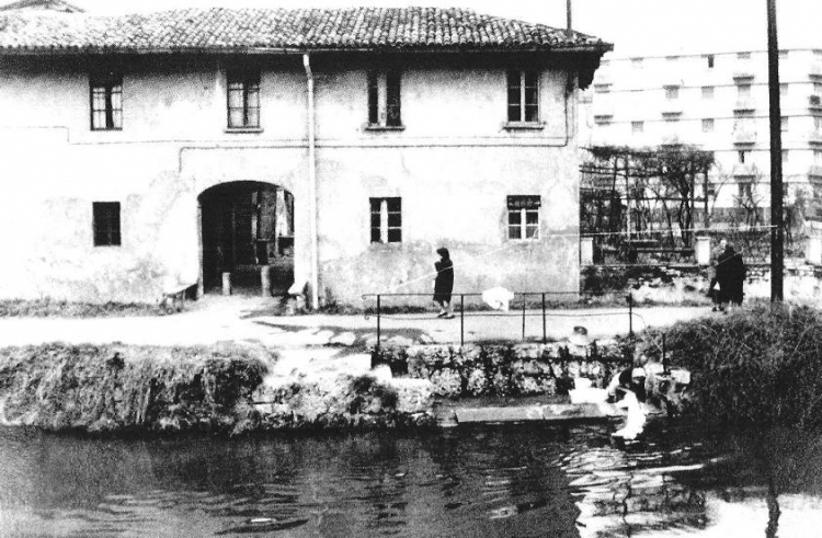 Cort di Mont, 1960. Davanti al portone della corte "El brelin", lavatoio in pietra con donna che lava i panni nel Naviglio. .